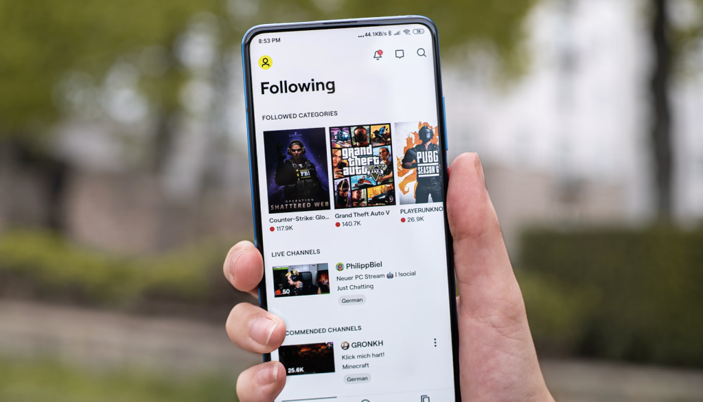 Alt text: "Hand holding smartphone with streaming app interface showing 'Following' section featuring game streams for Counter-Strike, Grand Theft Auto V, and PUBG. Live channel previews, follower counts, and popular creators' content visible. Creatorpoint – Creator Knowledge, Simplified. The best resources, podcast summaries, and learning for creators.