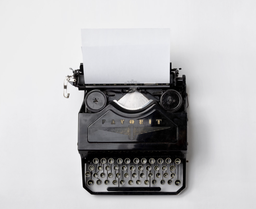 Alt Text: "Black vintage Favorit typewriter with blank white paper, ideal for podcast summaries and creative ideas. Round keys on a classic design, set against a plain white background. Creatorpoint – Creator Knowledge, Simplified. The best resources, podcast summaries, and learning for creators.