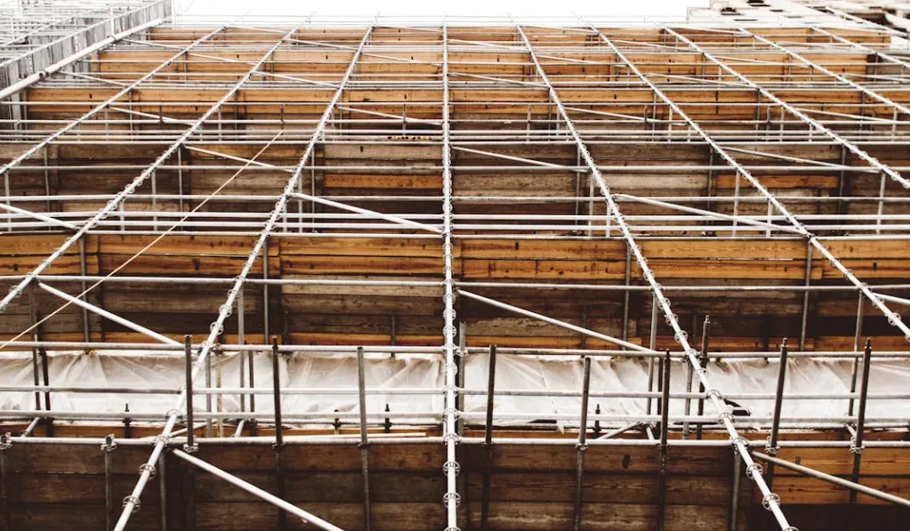 Scaffolding on a building under construction with metal poles and wooden planks forming multiple levels. Mesh netting ensures safety, similar to how writing tips for beginners offer essential support. Creatorpoint – Creator Knowledge, Simplified. The best resources, podcast summaries, and learning for creators.