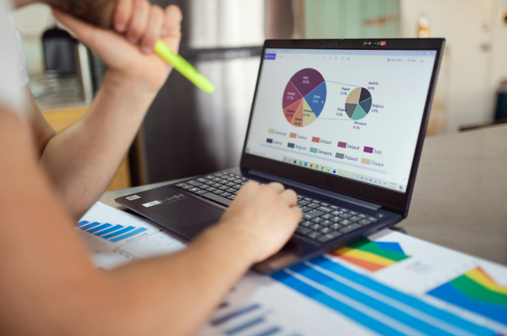 Alt Text: "Business Creator Analyzing Data on Laptop with Pie and Bar Charts, Highlighting Key Insights for Podcast Summary Preparation Creatorpoint – Creator Knowledge, Simplified. The best resources, podcast summaries, and learning for creators.