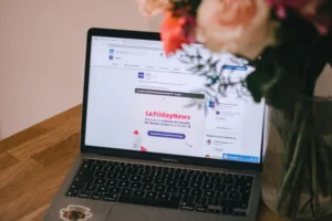 Open laptop on wooden table displaying 'La Friday News' promotional banner in French. Vase with flowers to the right hints at latest YouTube podcast episode by the creator. Perfect setup for digital marketing, online news updates, and multimedia content creation. Creatorpoint – Creator Knowledge, Simplified. The best resources, podcast summaries, and learning for creators.