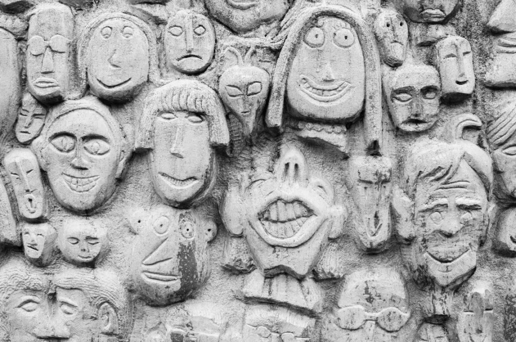 Intricately carved stone wall showcasing diverse human faces with unique expressions and hairstyles, each telling a distinct story. This narrative tapestry covers the entire surface, illustrating storytelling through art. Masterclass in expression and creativity on display. Creatorpoint – Creator Knowledge, Simplified. The best resources, podcast summaries, and learning for creators.