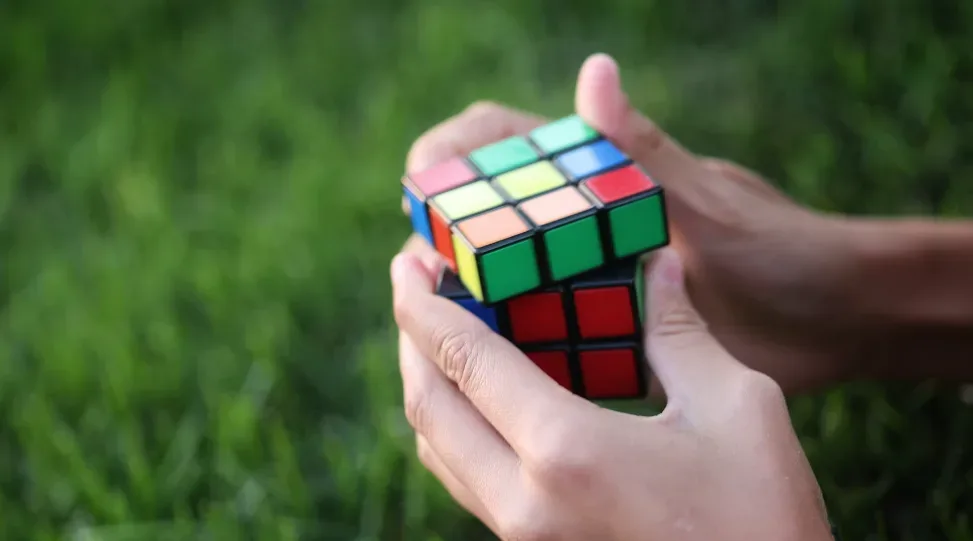 Person solving a Rubik's Cube in a grassy field, each colorful square symbolizing storytelling skills. Like storytelling, solving the cube involves patience and insight. Unravel layers to complete the puzzle, just as you would weave details into a captivating story. Creatorpoint – Creator Knowledge, Simplified. The best resources, podcast summaries, and learning for creators.