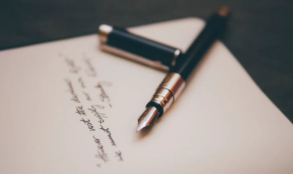 Fountain pen on open notebook page with handwritten tips for better storytelling, cap beside it; showcases cursive writing style inviting creativity. Slightly blurred background enhances focus on the pen as a tool for creative expression. Perfect for writers seeking storytelling inspiration and techniques. Creatorpoint – Creator Knowledge, Simplified. The best resources, podcast summaries, and learning for creators.