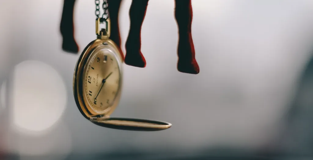 Gold pocket watch with open lid, hanging from chain like YouTube Shorts strategy. Blurred background with hint of red creates allure. Clock hands at 10:09 symbolize time's dance with opportunity in digital content. Optimize views by blending creativity and strategic timing for first-page indexing success. Creatorpoint – Creator Knowledge, Simplified. The best resources, podcast summaries, and learning for creators.