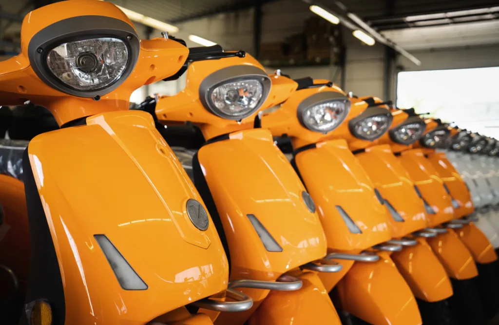 Vibrant orange scooters lined up in a garage with sleek design and headlights, set against an industrial backdrop. Perfect edgy setting for creating video content on gaining views on YouTube Shorts. Ideal visual for tutorials on successful video strategies in creative environments. Creatorpoint – Creator Knowledge, Simplified. The best resources, podcast summaries, and learning for creators.