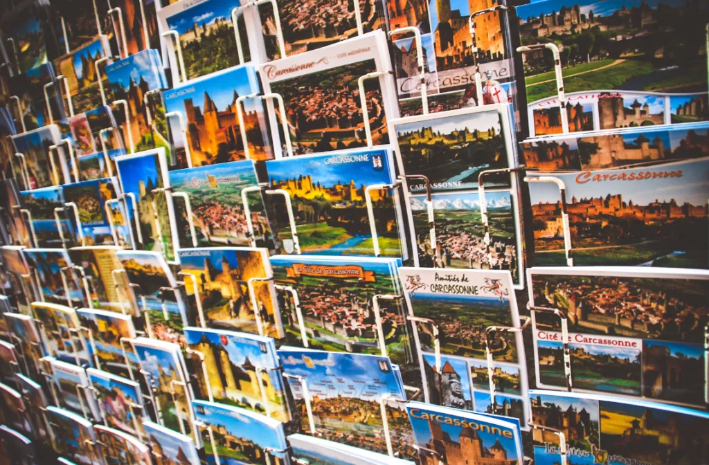 Display rack of Carcassonne postcards with regional landmarks, capturing diverse views like a curated YouTube Shorts gallery. Postcards arranged close for visual impact, featuring Carcassonne's architecture and scenic beauty, attracting attention in a bustling tourist setting. Creatorpoint – Creator Knowledge, Simplified. The best resources, podcast summaries, and learning for creators.